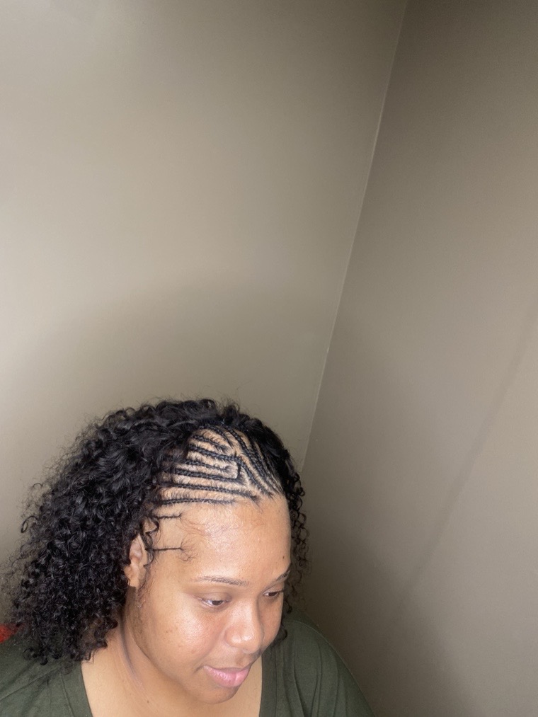 Feed-in cornrows braided back with natural curls left loose at the front.