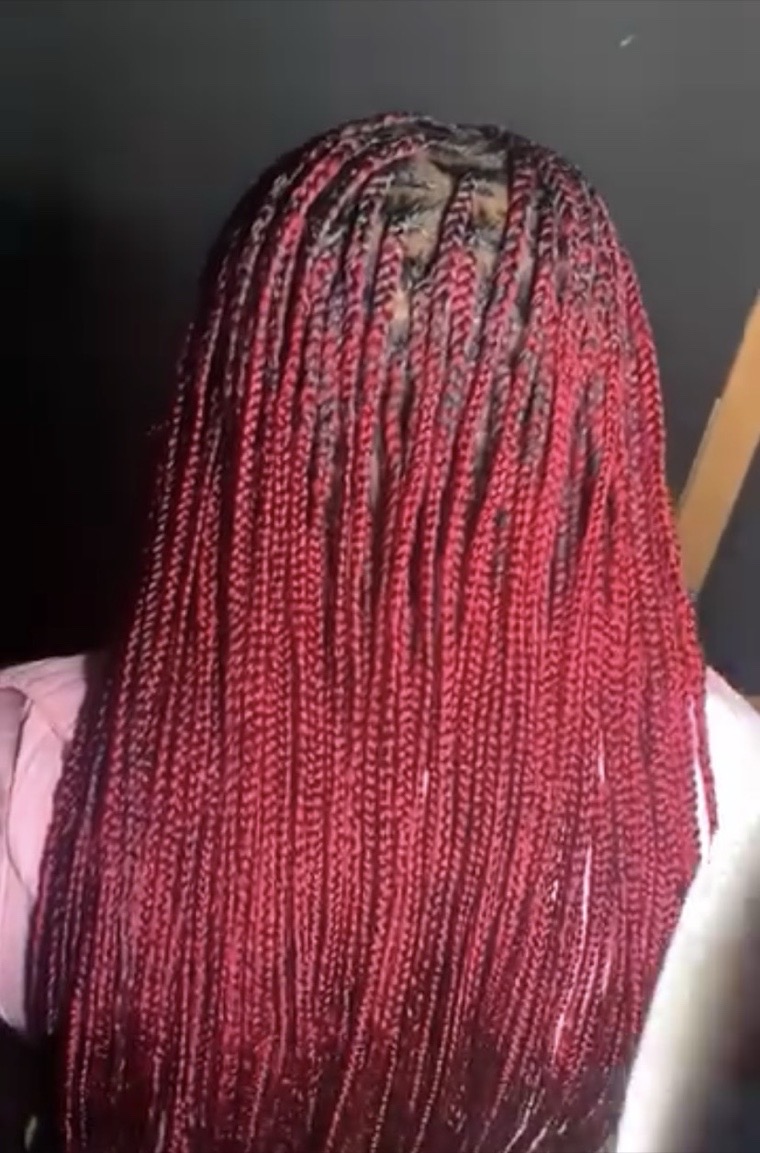 Long knotless braids in deep red, braided to hip length.